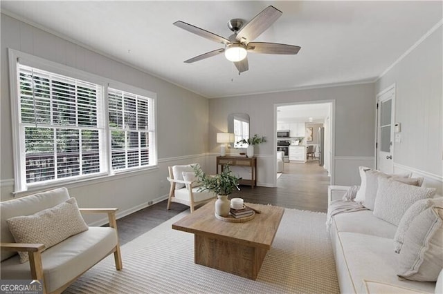 living room featuring ornamental molding, ceiling fan, and wood finished floors
