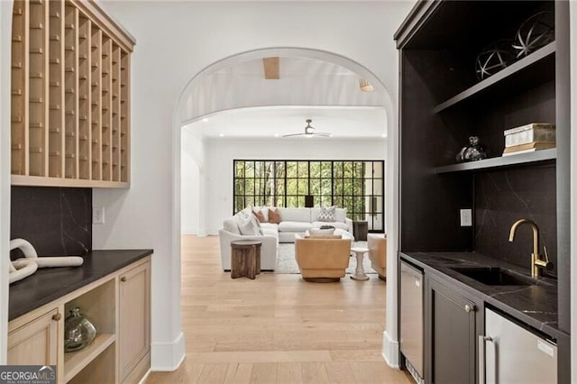 1074 Moores Mill Rd NW, Atlanta, GA 30327 - kitchen featuring dark countertops, open shelves, light wood-style flooring, tasteful backsplash, and arched walkways