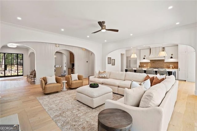 1074 Moores Mill Rd NW, Atlanta, GA 30327 - living room featuring arched walkways, ceiling fan, recessed lighting, light wood finished floors, and ornamental molding