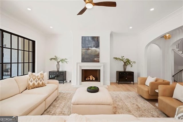 1074 Moores Mill Rd NW, Atlanta, GA 30327 - living area featuring stairway, ceiling fan, arched walkways, crown molding, and a fireplace with raised hearth