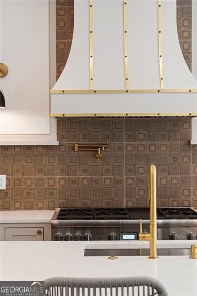 1074 Moores Mill Rd NW, Atlanta, GA 30327 - kitchen view of white cabinetry, light countertops, range, and decorative backsplash