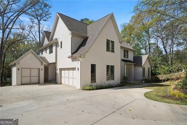 1074 Moores Mill Rd NW, Atlanta, GA 30327 - view of side of property featuring driveway, a garage, stucco siding, and a shingled roof