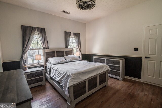 bedroom featuring dark wood finished floors and visible vents
