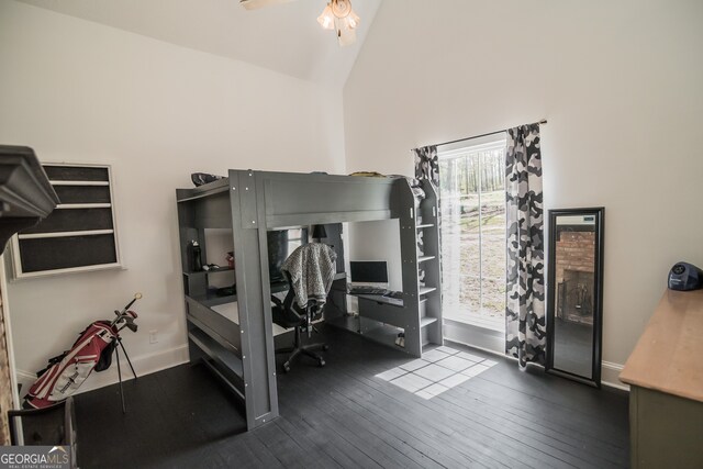 bedroom featuring hardwood / wood-style floors, high vaulted ceiling, and baseboards