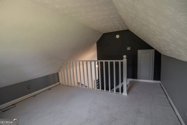 bonus room with baseboards, vaulted ceiling, carpet flooring, and a textured ceiling