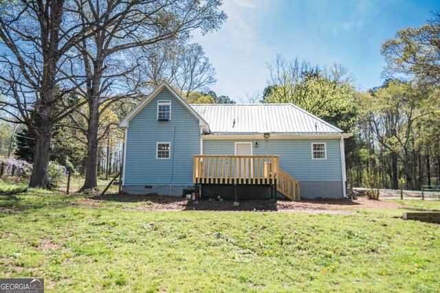 back of house featuring crawl space, metal roof, a yard, and a wooden deck