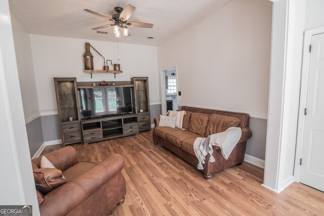 living area with baseboards, visible vents, light wood-style floors, and ceiling fan