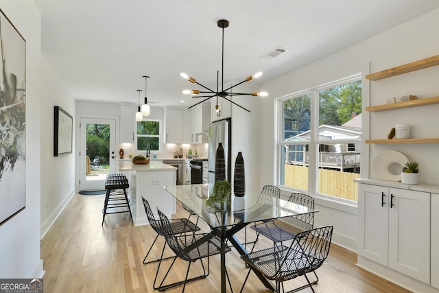 dining area featuring a wealth of natural light, light wood finished floors, and visible vents