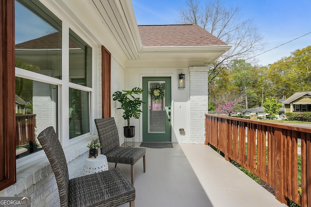 entrance to property featuring a shingled roof
