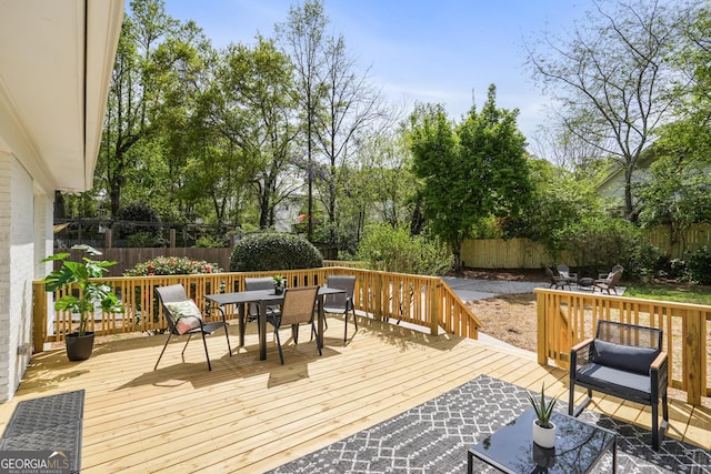 deck with a fenced backyard and outdoor dining space