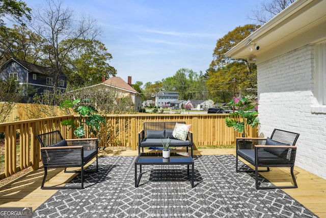 view of patio / terrace with an outdoor living space, fence, and a wooden deck