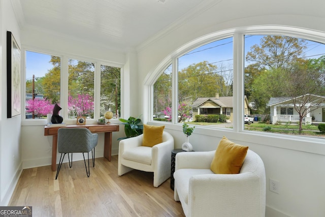sunroom / solarium with baseboards, wood finished floors, and crown molding