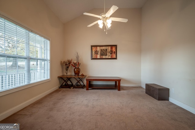 sitting room with baseboards, a ceiling fan, vaulted ceiling, and carpet