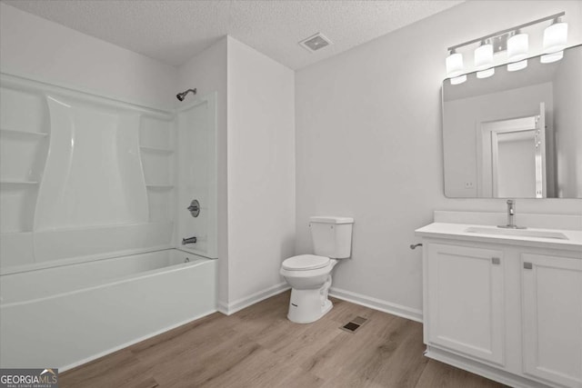 bathroom featuring vanity, toilet, a textured ceiling, visible vents, and wood finished floors