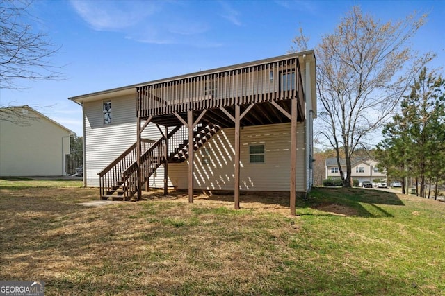 rear view of house featuring a wooden deck, stairway, and a yard