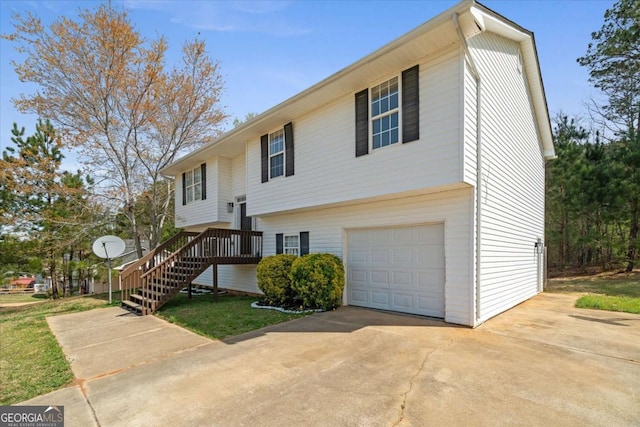 raised ranch featuring an attached garage, stairs, and driveway