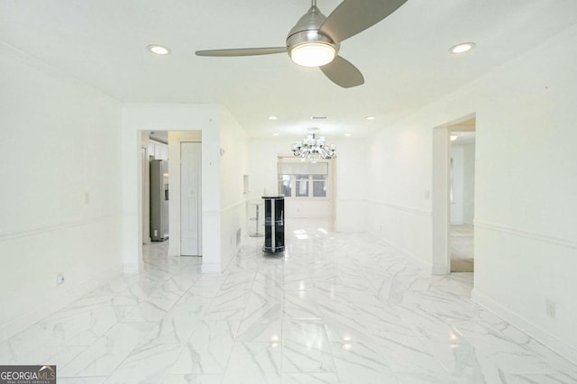 unfurnished room with baseboards, marble finish floor, recessed lighting, and ceiling fan with notable chandelier