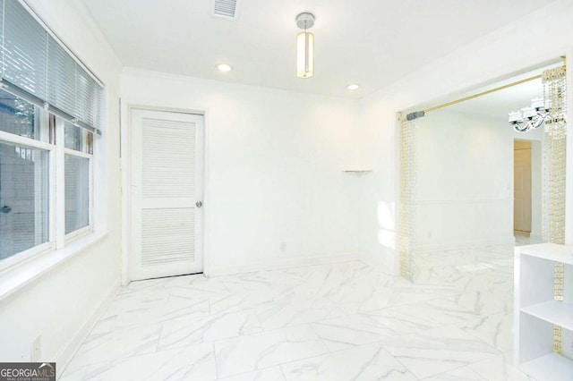 spare room with marble finish floor, baseboards, a chandelier, and visible vents