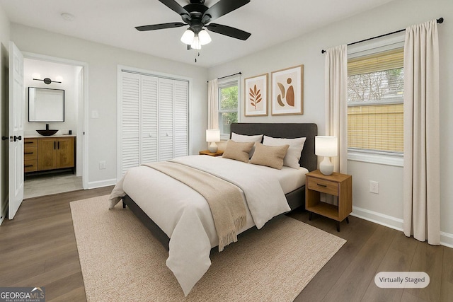 bedroom featuring a closet, ceiling fan, baseboards, and dark wood finished floors