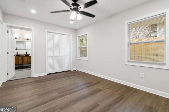 unfurnished bedroom with wood finished floors, ceiling fan, baseboards, and recessed lighting