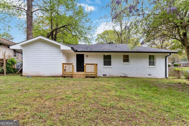 back of property with brick siding, crawl space, a deck, and a lawn