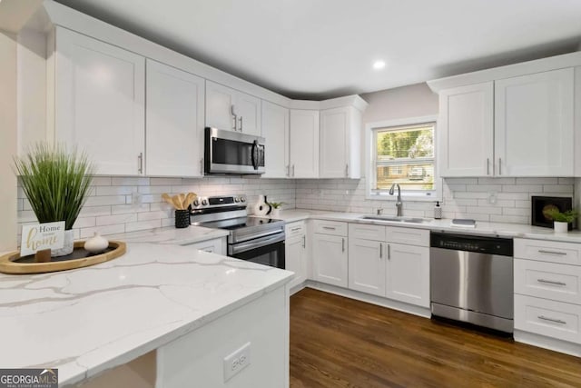 kitchen with a sink, dark wood-style flooring, appliances with stainless steel finishes, recessed lighting, and white cabinetry