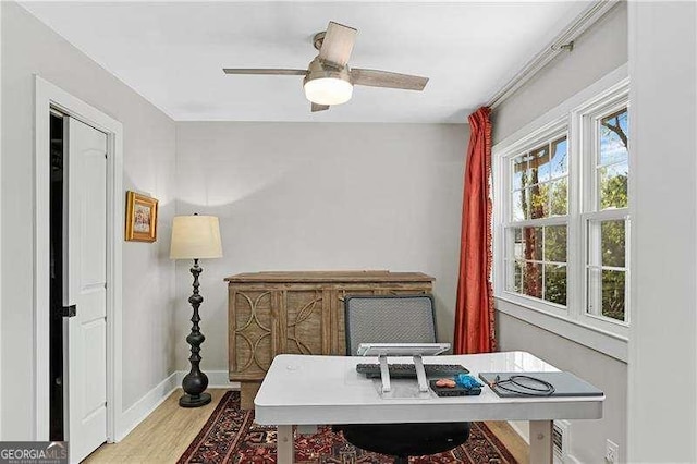 office space with baseboards, ceiling fan, and wood finished floors