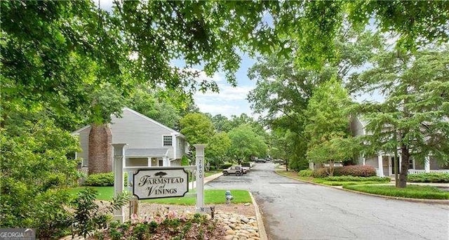 community sign with aphalt driveway