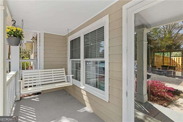 view of patio / terrace featuring a porch and fence