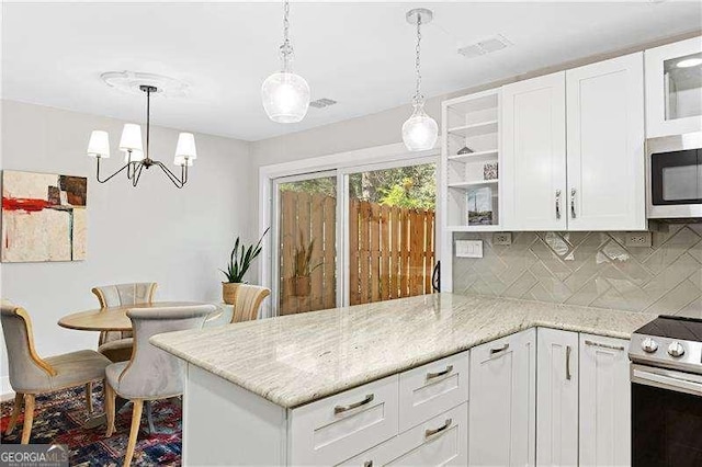 kitchen with a peninsula, appliances with stainless steel finishes, white cabinetry, open shelves, and backsplash