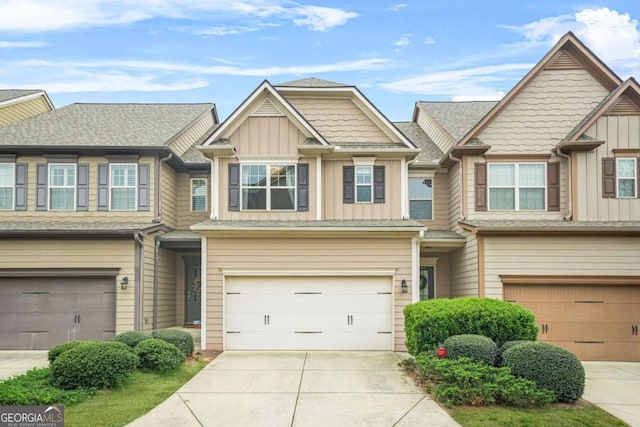view of property with driveway, an attached garage, and board and batten siding