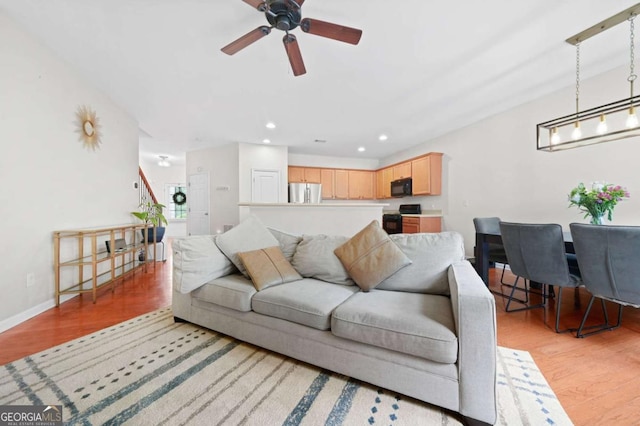 living room with baseboards, light wood-style flooring, ceiling fan, and recessed lighting