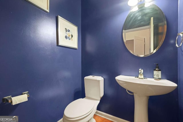 bathroom with baseboards and toilet
