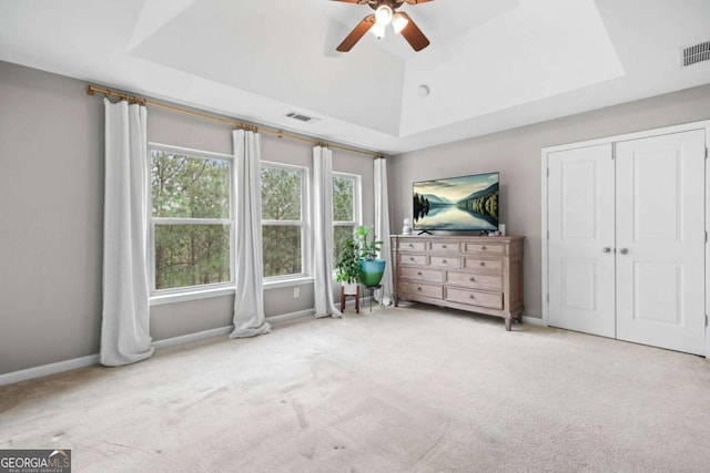 unfurnished bedroom featuring carpet floors, visible vents, and a raised ceiling