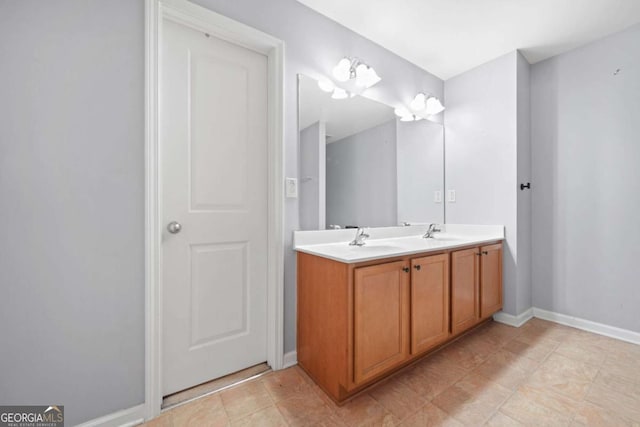 bathroom featuring double vanity, a sink, and baseboards