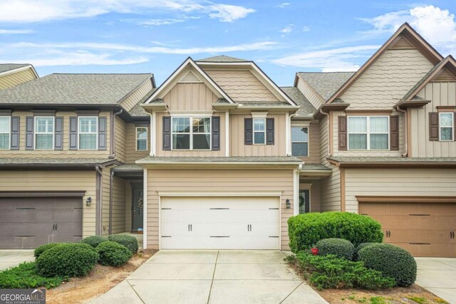 multi unit property with driveway, a garage, and board and batten siding