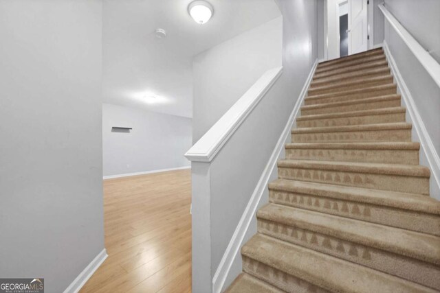 staircase featuring baseboards and wood finished floors