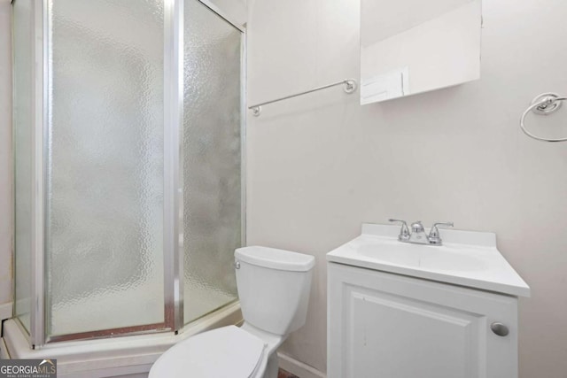 bathroom with vanity, toilet, and a shower stall