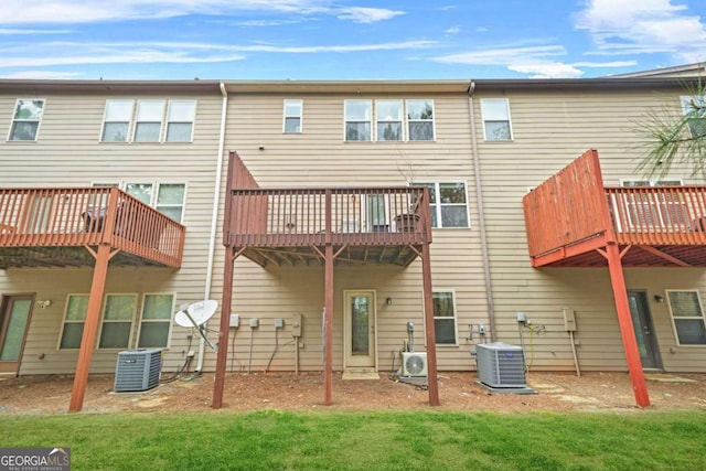 rear view of property with ac unit, central AC, and a yard