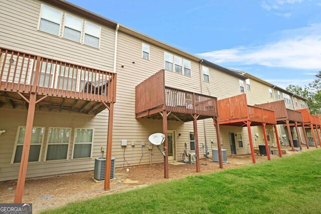 back of house featuring a lawn, central air condition unit, and a wooden deck