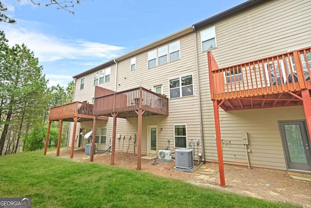 back of house featuring central air condition unit, a lawn, and a deck