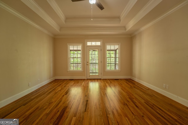 unfurnished room with a raised ceiling, wood finished floors, baseboards, and ceiling fan
