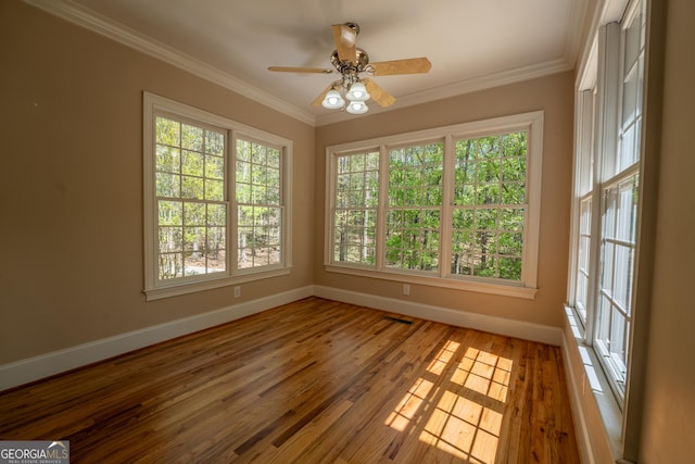 spare room with a ceiling fan, baseboards, ornamental molding, and wood finished floors