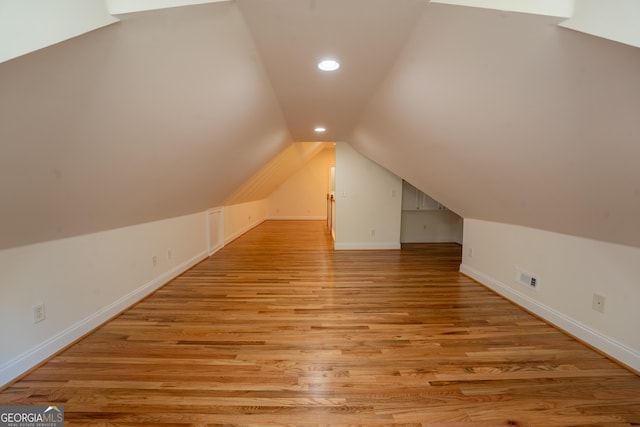 bonus room featuring vaulted ceiling, light wood-style floors, visible vents, and baseboards