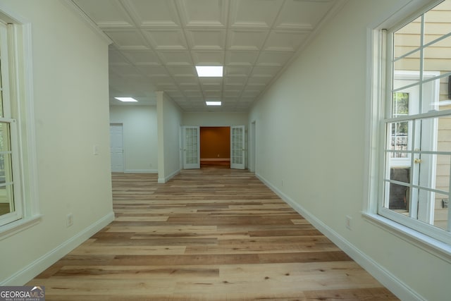 hall featuring light wood finished floors and baseboards