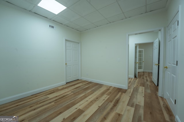 spare room with light wood finished floors, baseboards, and visible vents