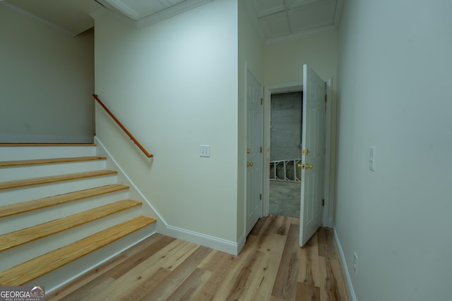 staircase featuring attic access, baseboards, ornamental molding, and wood finished floors