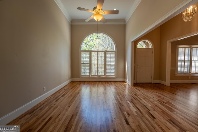 entrance foyer with baseboards, wood finished floors, and crown molding