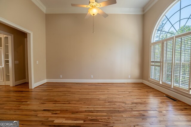 spare room with ceiling fan, baseboards, crown molding, and light wood-type flooring