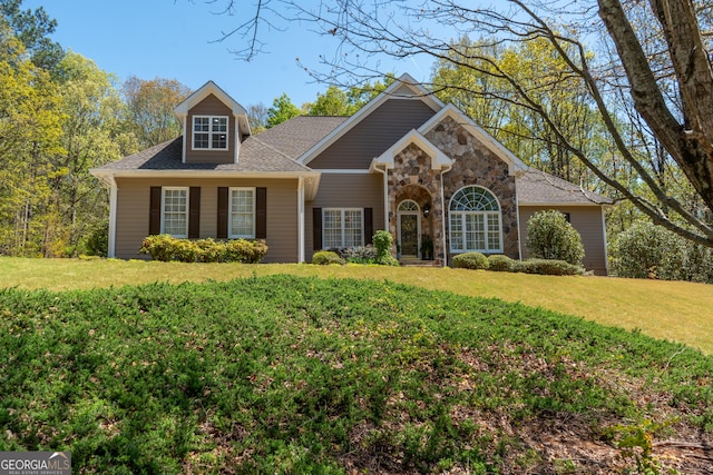 craftsman inspired home with a shingled roof, stone siding, and a front lawn